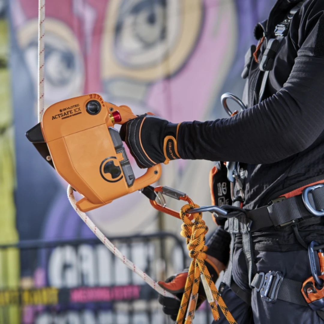 persoon met harnas aan bezig met apparatuur