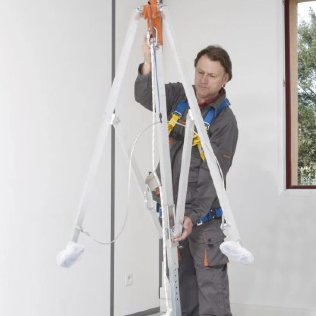 man met harnas aan bezig met driepoot aan plafond