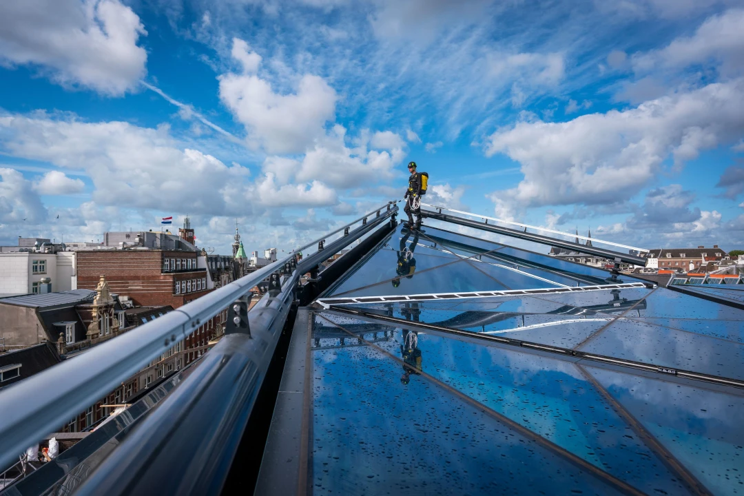 een glazen dak met een railysteem erop gemonteerd