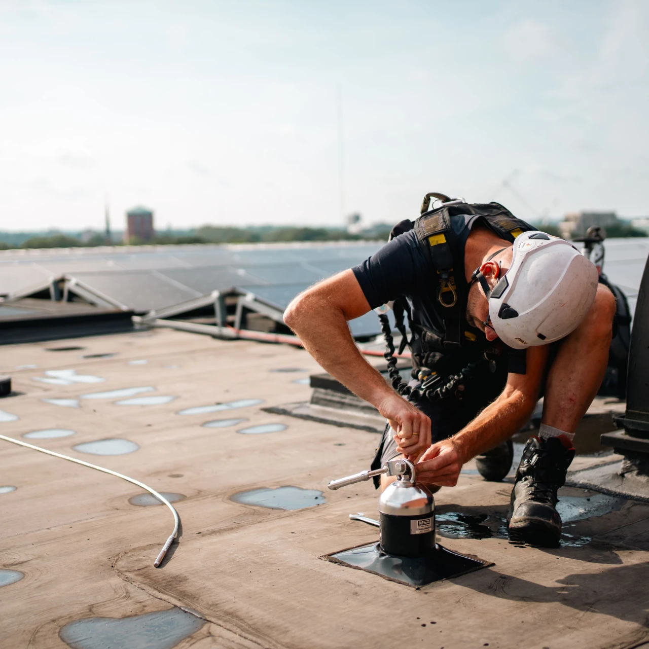 een man die op een dak een ankerpunt bevestigt