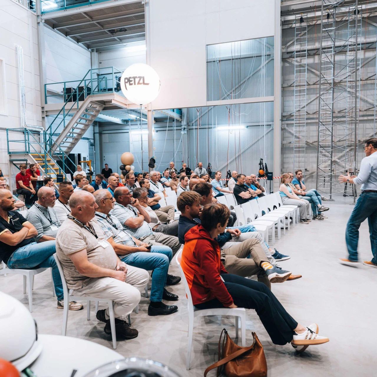 een mannelijke spreker die praat tegen tientallen bezoekers