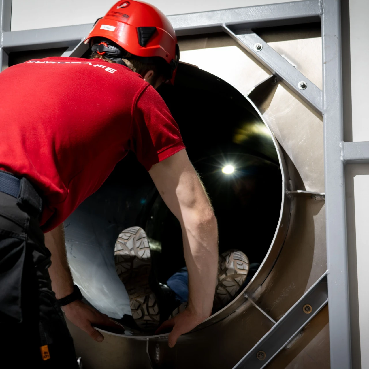 man die persoon helpt in besloten ruimte met helm op