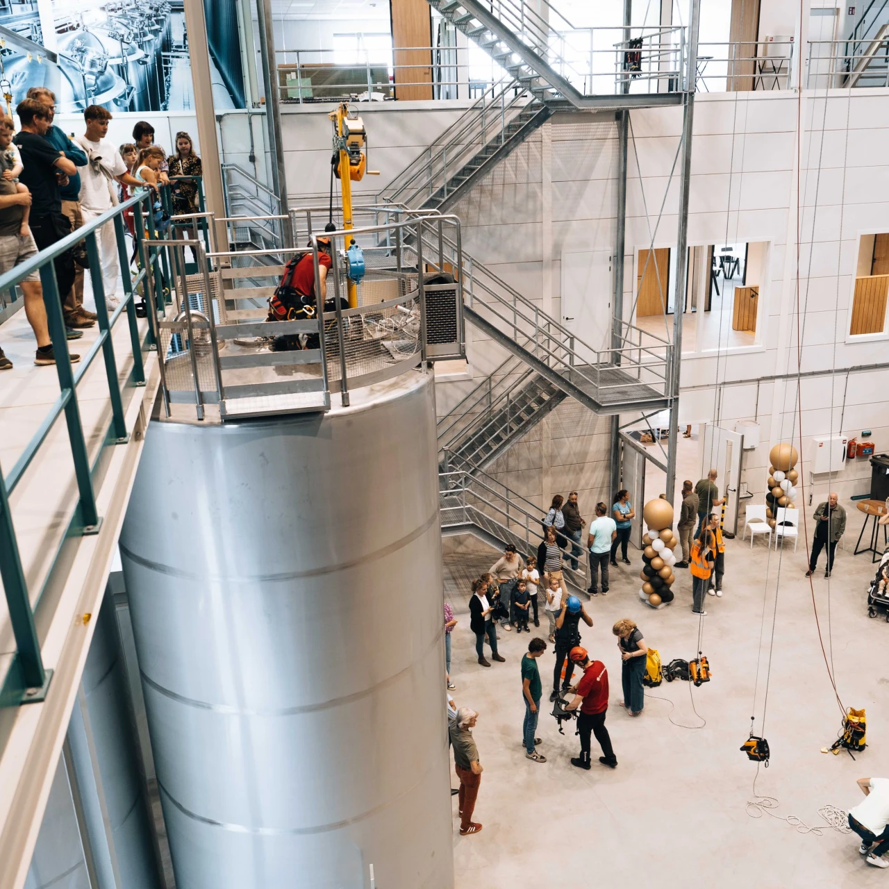 een trainingshal gevuld met silo's touwbrommers en harnassen