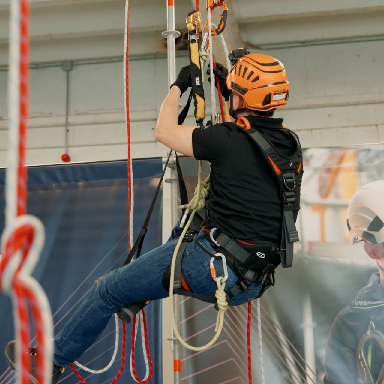 man in harnas aan touwen hangend