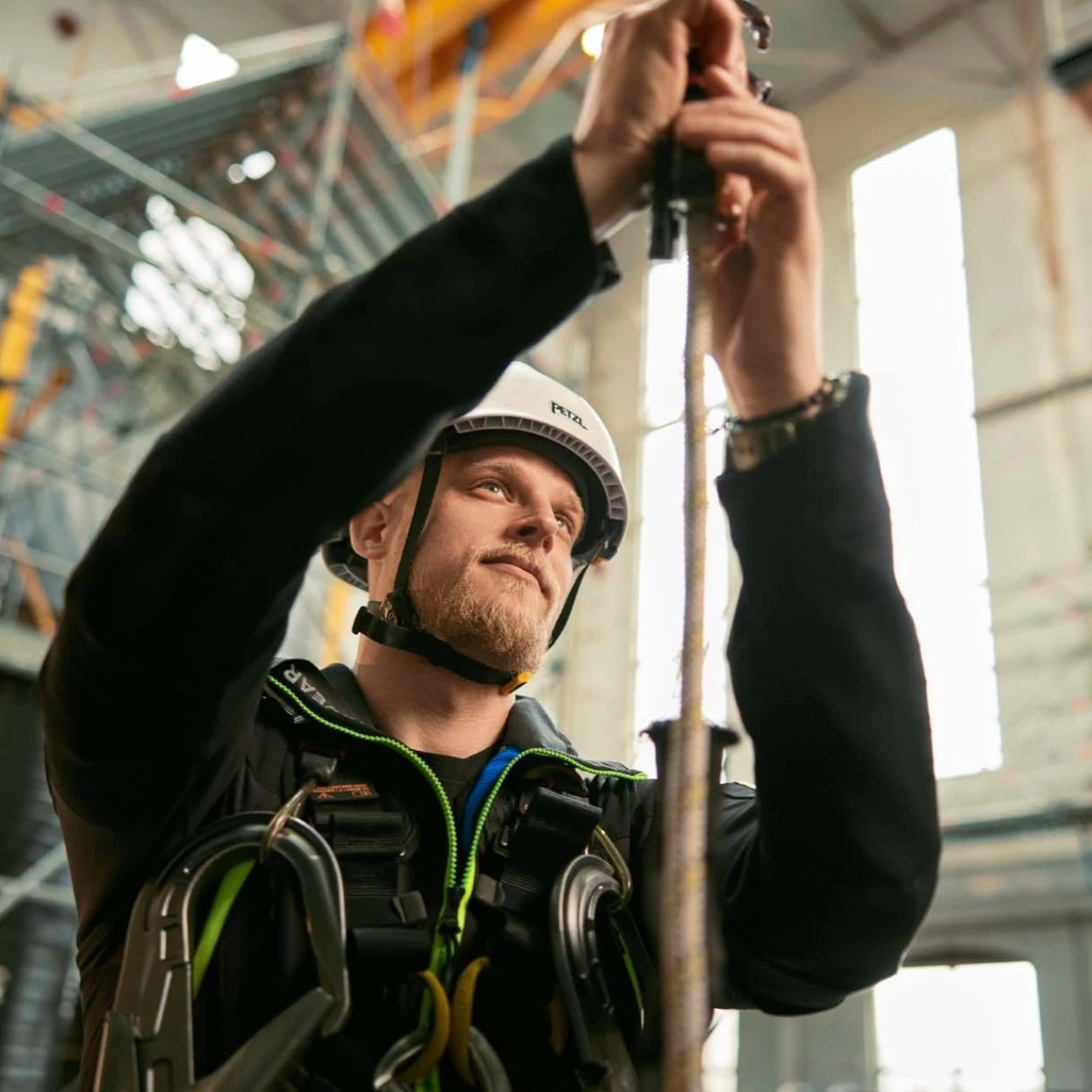 man met helm en harnas die touw vasthoudt