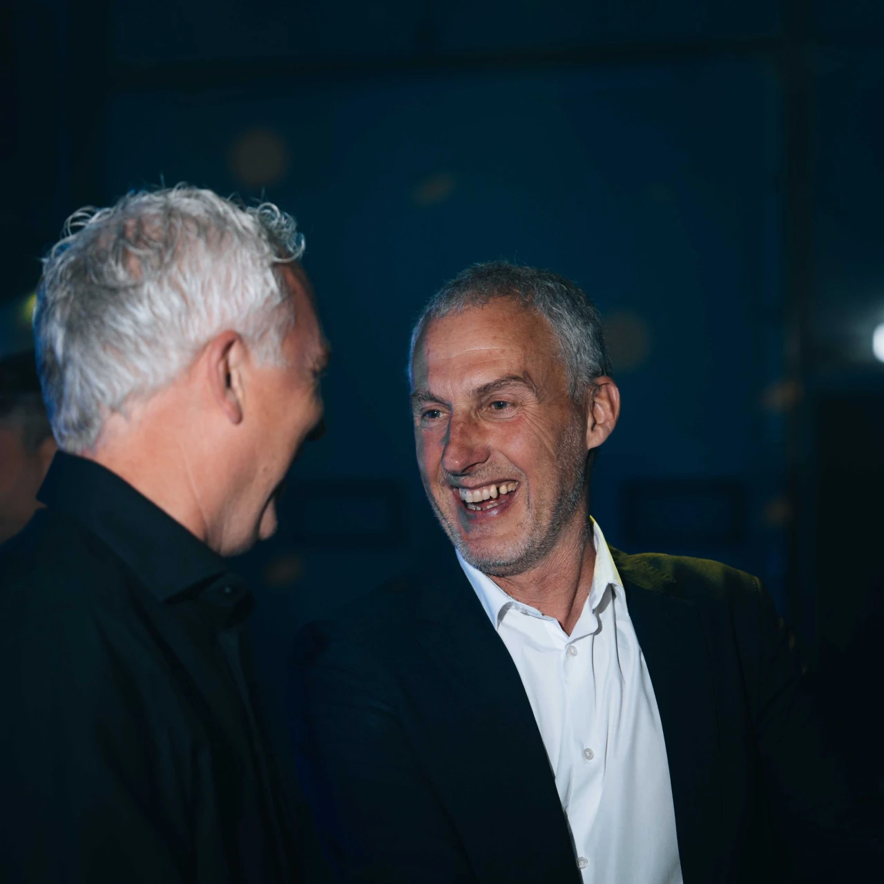 twee mannen die naar elkaar lachen