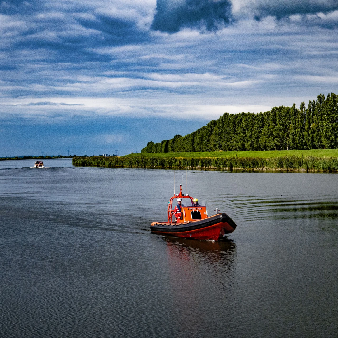 rode boot op water met bomen erachter