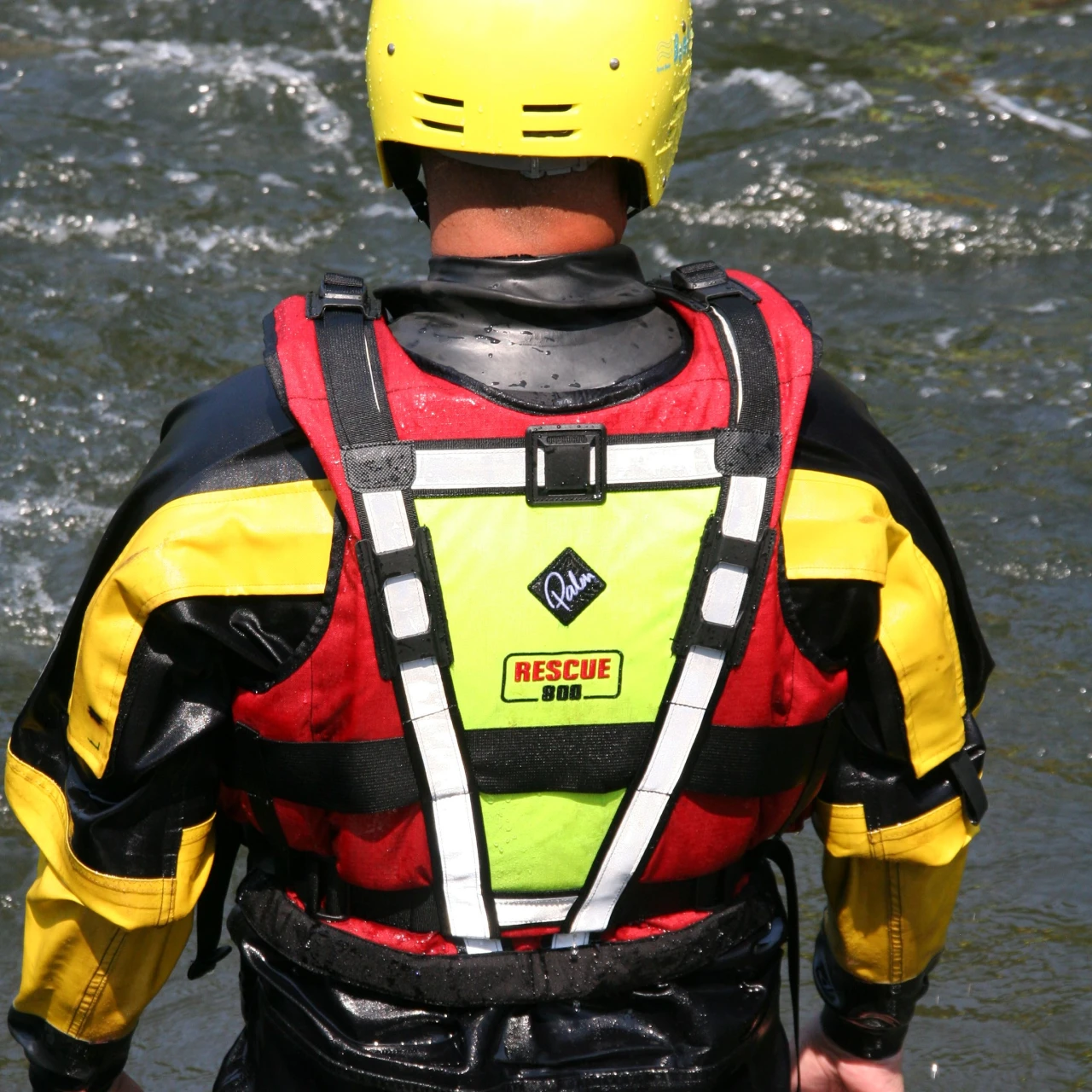 man met reddingsvest en helm bij water