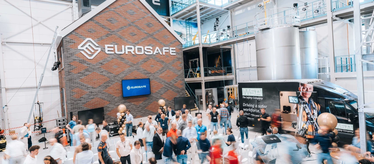 Een huis die staat in een trainingshal waarbij er personen rondlopen
