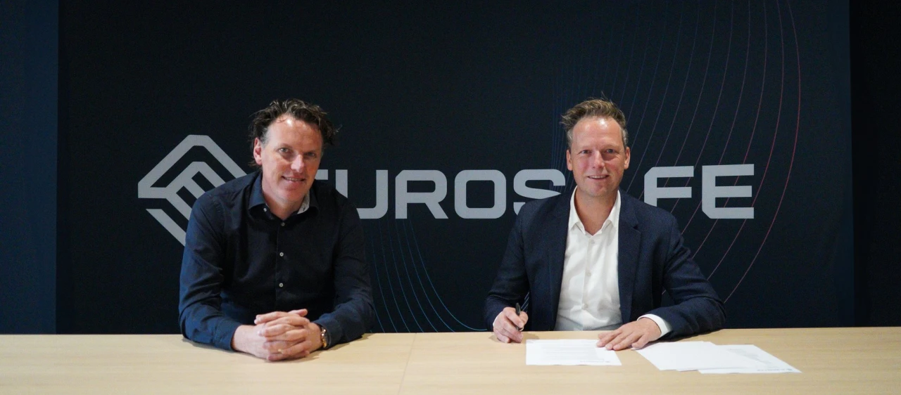 Twee mannen die naast elkaar zitten om een contract te tekenen.