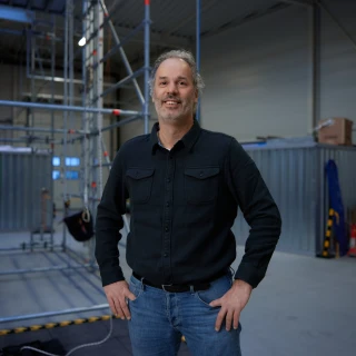man met grijs haar en lachende voor de foto