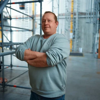 man met armen over elkaar in loods