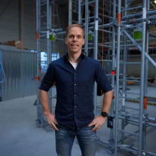 blije man poserend in loods