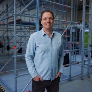 man poserend in hal met handen in zakken