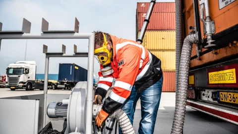 man die met gasmasker op iets aan het meten is met een slang