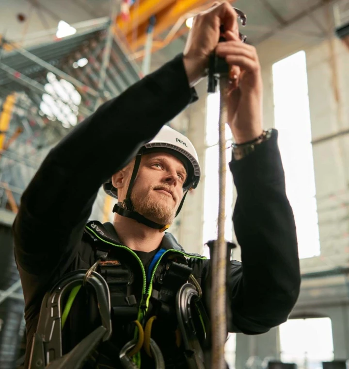 man met helm en harnas die touw vasthoudt