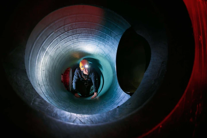 man met helm en lamp in besloten ruimte