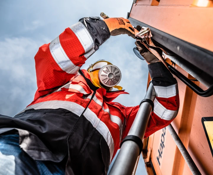 man met gasmasker en pak aan bezig met slang