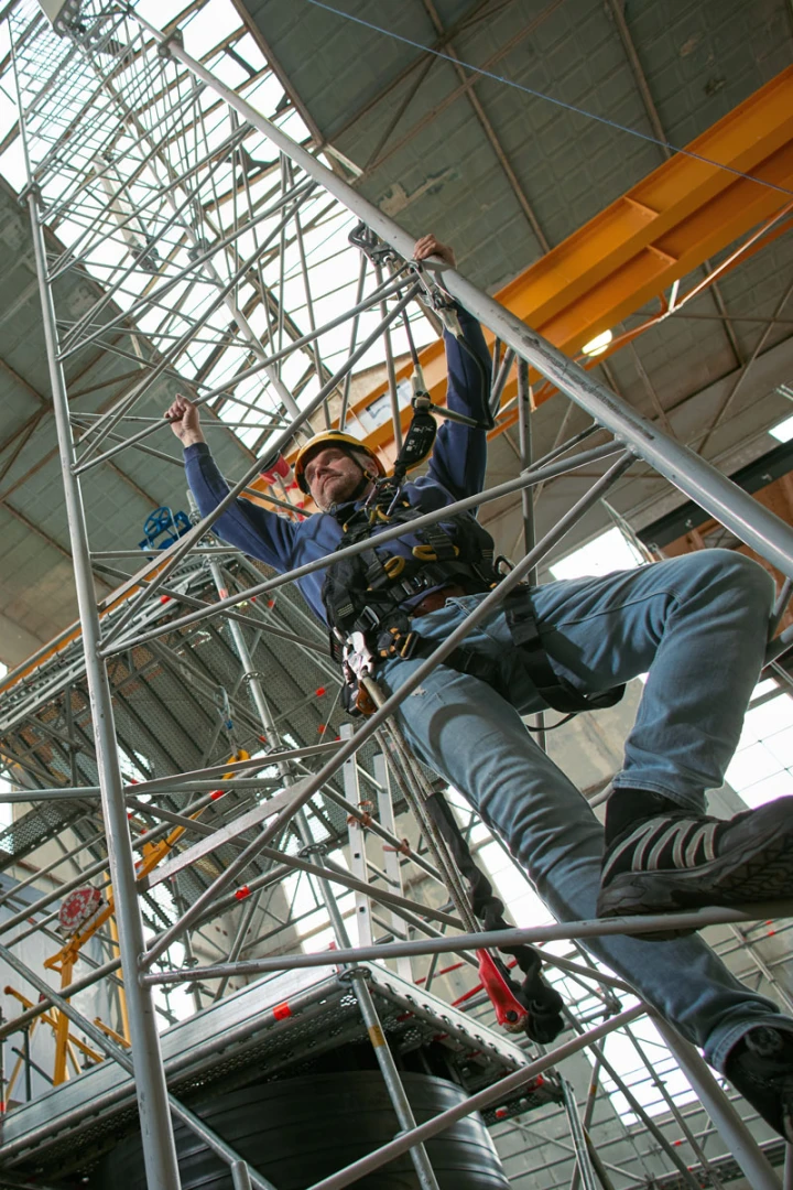 man op trap die hoogte in gaat