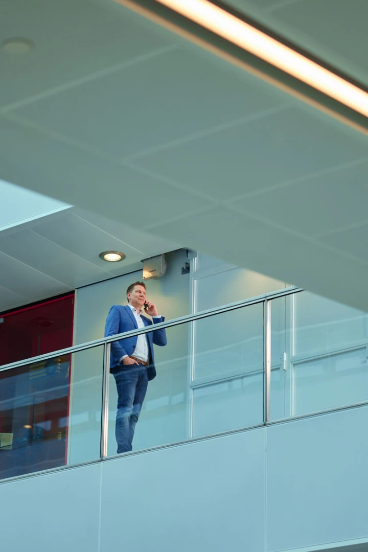 man bellend bij een leuning in een gebouw