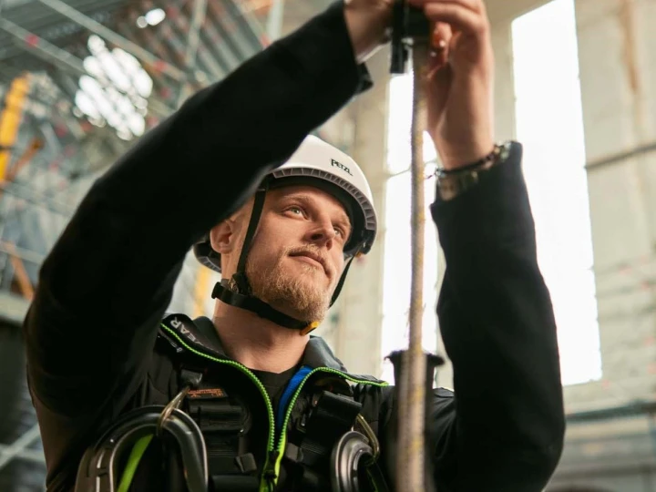 man met helm en harnas die touw vasthoudt