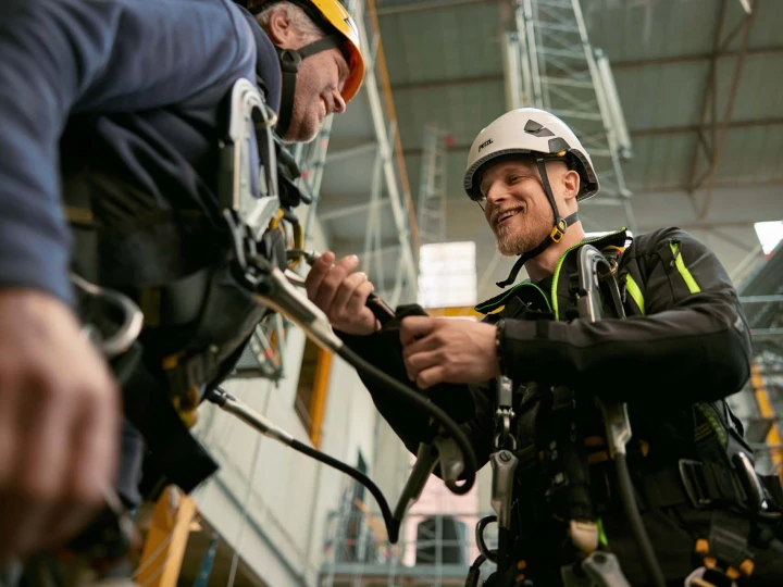 lachende mannen die elkaar helpen met een harnas