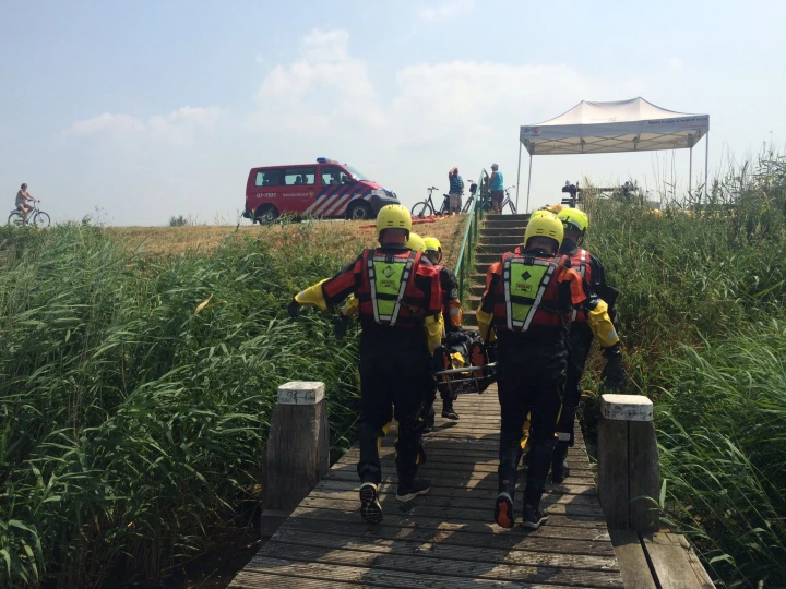 mannen die iemand redden op brancard met helm op