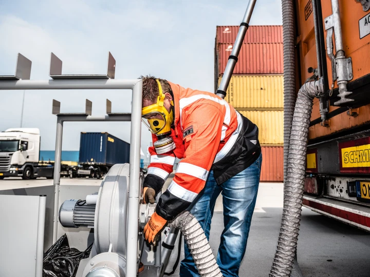 man die met slang en gasmasker aan het meten is
